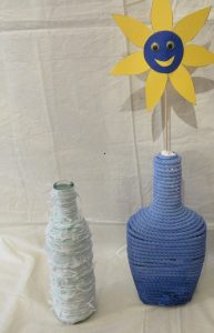 Vase aus Flasche mit Wollresten und Wunschblume